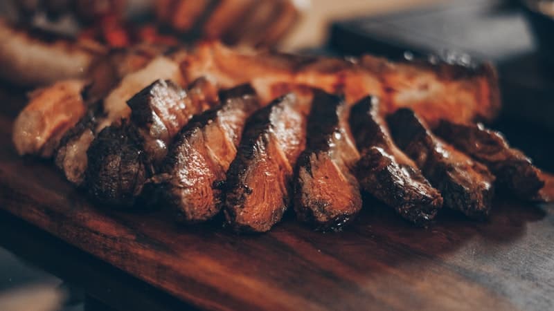 Ribeye, NY strip, and filet mignon steaks on a dark surface